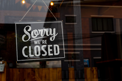 a business showing a "closed" sign because they are experiencing a power failure